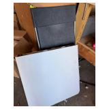 White folding table with black folding chair