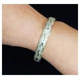 Sterling silver hinged bangle bracelet with a starburst and wave etched design.
