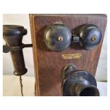 Antique Western Electric oak cased wall-mounted crank telephone, commonly used in the early 20th century