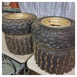 Set of used ATV tires mounted on gold-colored rims