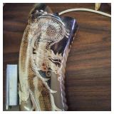 This item is a decorative collectible hand-painted cow skull adorned with Native American-inspired artwork and associated horn accessories.