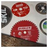 A collection of cutting tools, primarily circular saw blades for power saws and traditional hand saws.