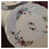 Collection of vintage porcelain and glass dishes, featuring various floral patterns, gilded rims, and crystal designs.