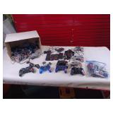 Collection of vintage video game accessories and plug-and-play consoles including PlayStation 2 and PlayStation 1 controllers