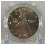 1992 D-Olympic Baseball Commemorative Uncirculated Silver Dollar - just the coin in a protective plastic case, one appears to have slight fire damage 1992 D-Olympic Baseball Commemorative Uncirculated Silver Dollar - just the coin in a protective plastic case, one appears to have slight fire damage