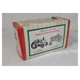 Diecast John Deere Model A tractor features a green body with yellow spoked wheels and detailed engine components. Packaged in the original window box labeled Farm Classics by ERTL. Classic farm toy r