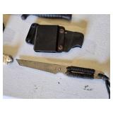Lot of three knives including Smith & Wesson H.R.T., two other knives with paracord-wrapped handles, and sheaths