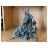 Bronze-colored seated woman figure... Bronze-colored seated woman figure...