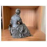 Bronze-colored seated woman figure... Bronze-colored seated woman figure...