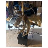 This Lot is a 1970s Hollywood Regency-style table lamp, featuring a sculpted metal base and a pleated shade