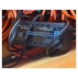 Wood box with electrical cords, battery tender and power strip.