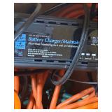 Wood box with electrical cords, battery tender and power strip.
