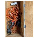 Wood box with electrical cords, battery tender and power strip.