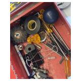 Red metal toolbox with assorted hand tools and accessories including pliers, screwdrivers, a utility knife, and a socket set