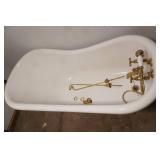 Fiberglass Slipper Clawfoot bathtub featuring polished gold-toned feet and brass hardware.