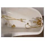 Fiberglass Slipper Clawfoot bathtub featuring polished gold-toned feet and brass hardware.