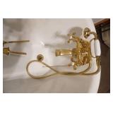 Fiberglass Slipper Clawfoot bathtub featuring polished gold-toned feet and brass hardware.
