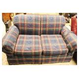 Plaid loveseat upholstered in navy, red, and green fabric. Approx. 57 Inch Long
