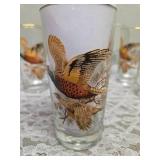 Pitcher with 5 glasses.  These items are likely produced by the "West Virginia Glass" likely from the mid-century era, featuring a distinctive pheasant-in-flight design with gold rim embellishments.
