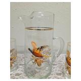 Pitcher with 5 glasses.  These items are likely produced by the "West Virginia Glass" likely from the mid-century era, featuring a distinctive pheasant-in-flight design with gold rim embellishments.
