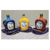Three upcycled Crown Royal whiskey decanters that appear to be hand painted and decoupaged. The bottles come with Crown Royal velvet bags.The artist signature is Bickford that appears on the decanter.