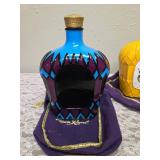 Three upcycled Crown Royal whiskey decanters that appear to be hand painted and decoupaged. The bottles come with Crown Royal velvet bags.The artist signature is Bickford that appears on the decanter.