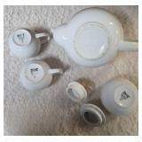 Vintage porcelain tea set featuring a teapot with a rattan handle, a creamer, and a sugar bowl, similar in style to Japanese or German postmodern designs from the mid-to-late 20th century.