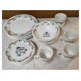 Four piece setting of Home Essentials Woodland Celebration dinnerware set.  Featuring snowman and holly branch patterns.