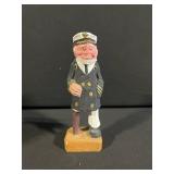 Three-Piece Display Lot: Figurine in Wire Basket & Native American Headdress Brick Plaque and Carved Wooden Capatin