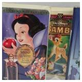 Assorted VHS movies including Disney titles Snow White, Bambi, Monsters Inc, and Hercules along with Hulk. Mixed family and animated films in standard VHS cases shown.