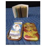 Mini book of 50 Pokémon cards and a Pokémon tin with an unopened pack of Pokémon cards