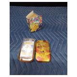 Mini book of 50 Pokémon cards and a Pokémon tin with an unopened pack of Pokémon cards