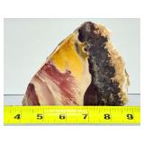 Mookaite Jasper is a unique Australian gemstone formed from ancient fossilized sea creatures that is prized by collectors for its vibrant, porcelain-like colors found in both raw slabs and smooth palm