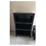 Black solid bookcase and round table