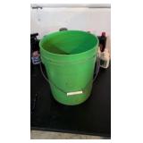 hodgepodge of oil and other random liquids in a green bucket