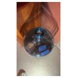 Glass gallon jug with pennies.