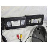 Various Electronics and Accessories Including VHS Tapes, Remotes, and Headphones