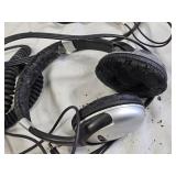 Various Electronics and Accessories Including VHS Tapes, Remotes, and Headphones