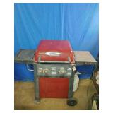 This is a red Brinkmann 2-burner propane gas grill with folding side shelves.