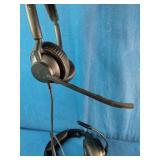 Two distinct wired headsets resting on a blue textured fabric background.