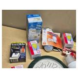 Various Light Bulbs and Wall Clock including Westinghouse Daylight Twist, EverBrite LED, and Sunbeam Anti-Insect Bulbs