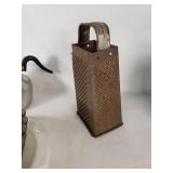 Vintage kitchenware including Glasbake and Tupperware dishes, ABCO aluminum pitcher, Vollrath stainless steel pitcher, and a metal grater with mold pan