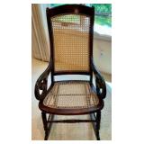 Vintage rocking chair cherry wood framed, light colored woven cane back and seat