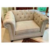 Cream colored velvet armchair with deep-button tufting and rolled arms