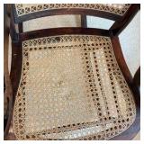 Vintage rocking chair cherry wood framed, light colored woven cane back and seat