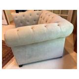 Cream colored velvet armchair with deep-button tufting and rolled arms