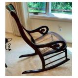 Vintage rocking chair cherry wood framed, light colored woven cane back and seat