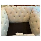 Cream colored velvet armchair with deep-button tufting and rolled arms