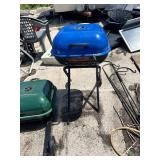 Portable charcoal grills, one green and one blue