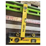 Assorted Levels and Measuring Tools including Laser Level, Stanley Level, Metal T-Square, and Carpenter Levels
